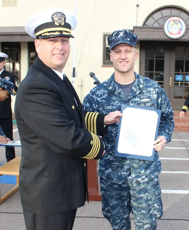 Stu in US Navy dress uniform receiving an award at a ceremony in San Diego